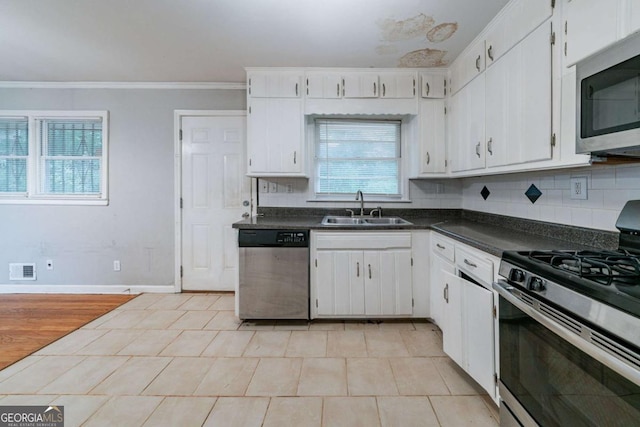 kitchen featuring sink, white cabinets, stainless steel appliances, and ornamental molding