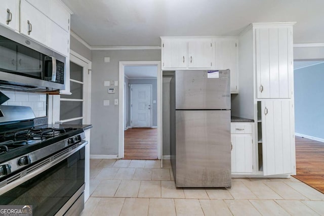 kitchen with appliances with stainless steel finishes, crown molding, decorative backsplash, white cabinets, and light wood-type flooring