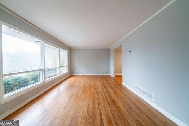 unfurnished room featuring light hardwood / wood-style flooring and ornamental molding