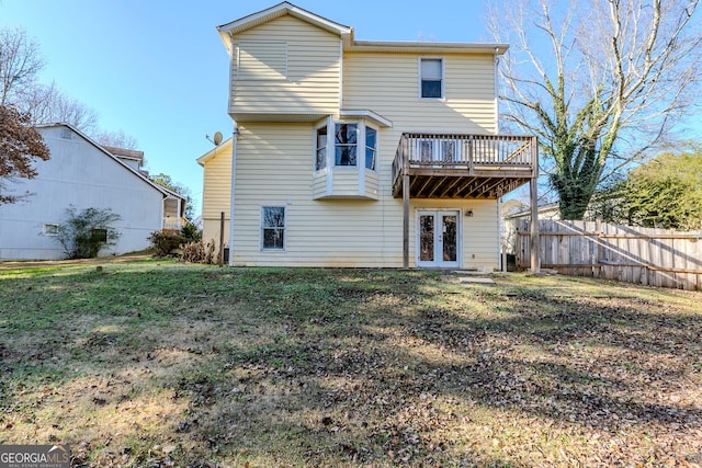 rear view of property with a yard, french doors, and a deck