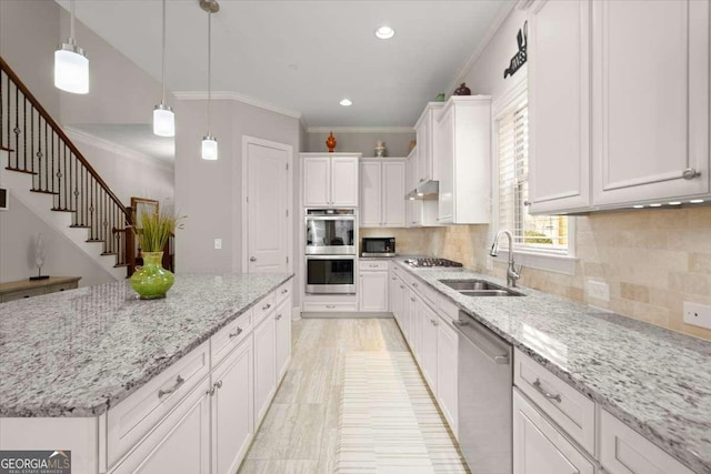 kitchen with white cabinets, pendant lighting, stainless steel appliances, and light stone counters