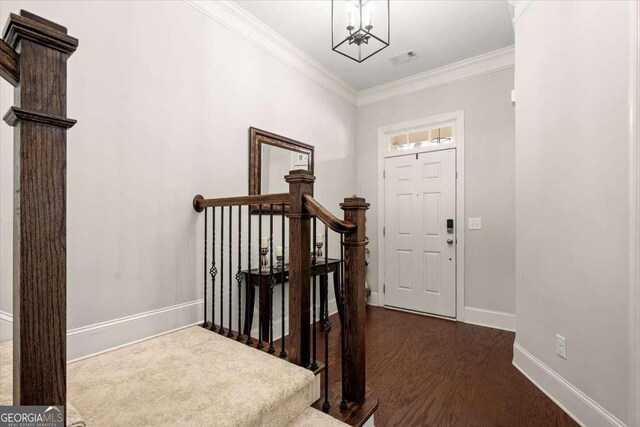 foyer with dark wood-type flooring and ornamental molding