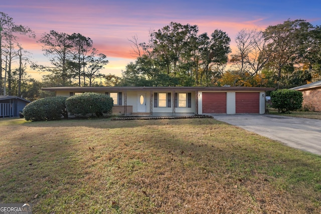 ranch-style home featuring a yard and a garage