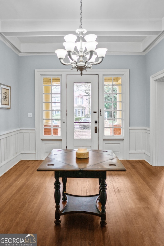 interior space featuring a wealth of natural light, wood-type flooring, and a notable chandelier