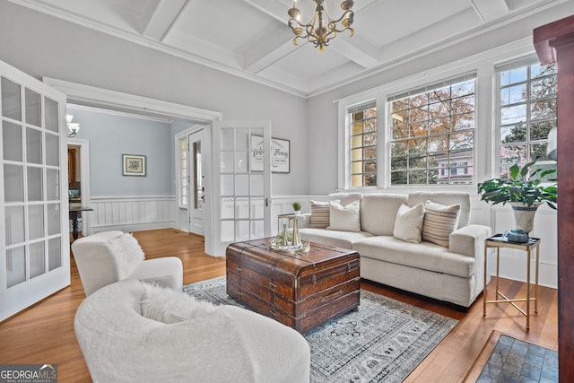 living room with beam ceiling, an inviting chandelier, plenty of natural light, and coffered ceiling