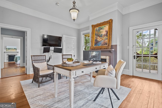 office with plenty of natural light, ornamental molding, and light hardwood / wood-style flooring