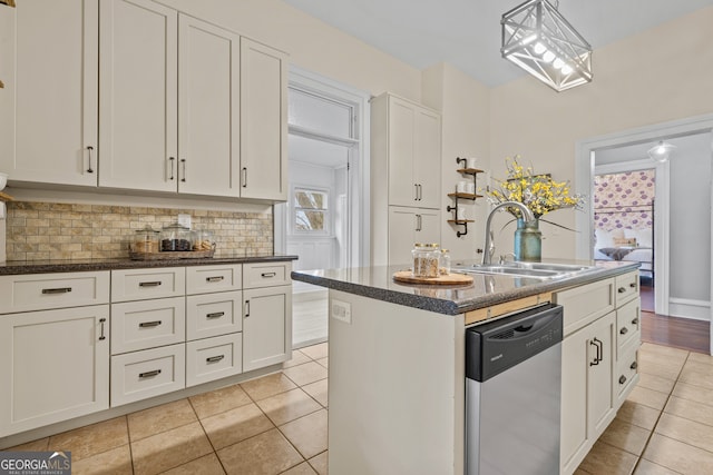 kitchen with stainless steel dishwasher, a center island with sink, white cabinetry, and sink