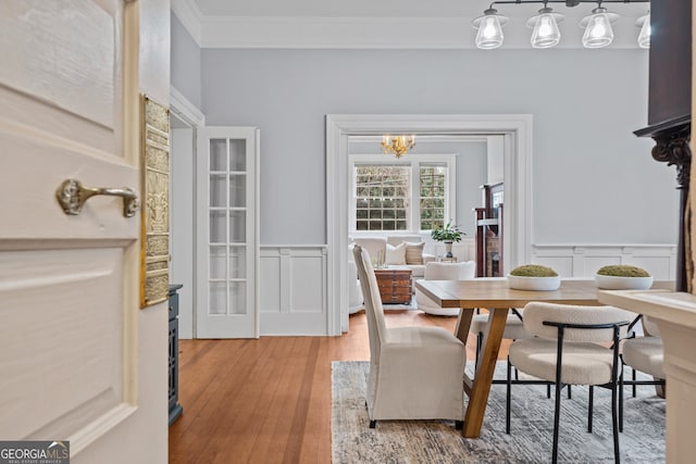 dining area featuring hardwood / wood-style floors, a notable chandelier, and ornamental molding