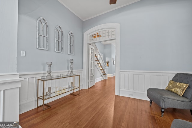 living area with ceiling fan, hardwood / wood-style floors, and ornamental molding