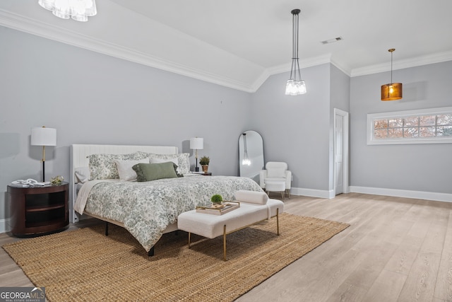 bedroom with light wood-type flooring, lofted ceiling, and ornamental molding