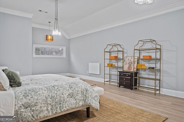 bedroom with ornamental molding, light wood-type flooring, and lofted ceiling