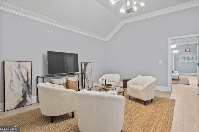 living room with an inviting chandelier, lofted ceiling, crown molding, and light hardwood / wood-style flooring