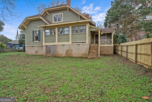 rear view of property featuring a lawn