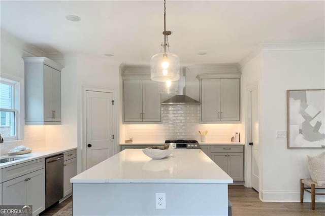 kitchen featuring a center island, wall chimney range hood, hanging light fixtures, stainless steel dishwasher, and gray cabinets