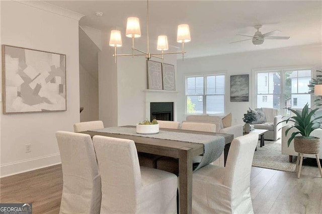 dining area featuring hardwood / wood-style floors and ceiling fan with notable chandelier