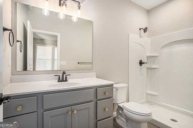 bathroom with vanity, toilet, and walk in shower