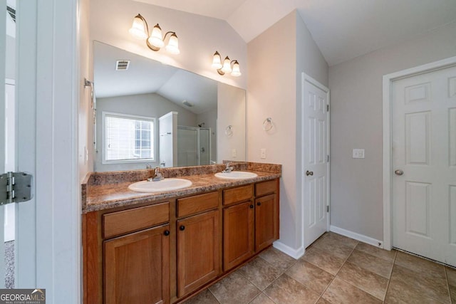 bathroom with tile patterned flooring, vanity, vaulted ceiling, and a shower with shower door