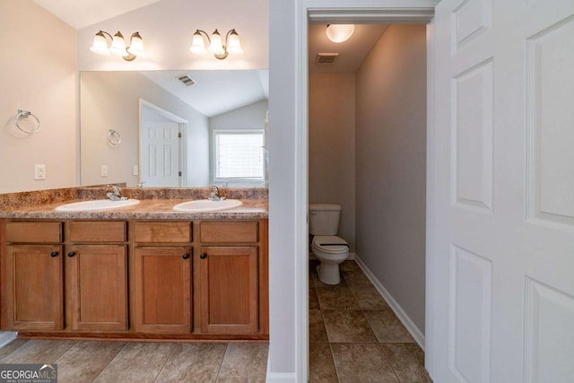 bathroom featuring vanity, toilet, and lofted ceiling