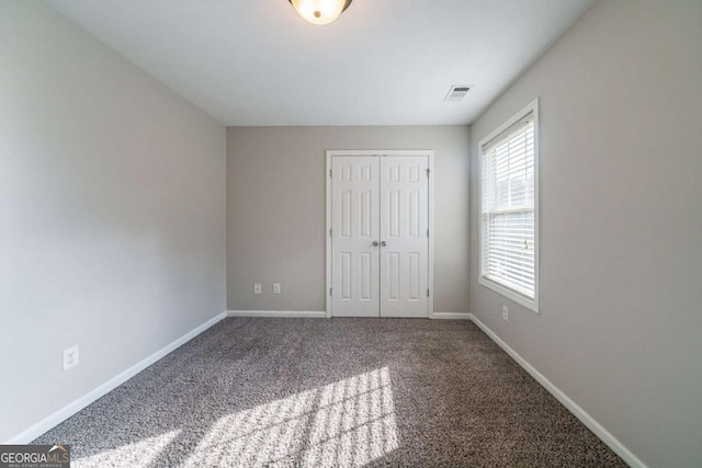 unfurnished bedroom featuring carpet and a closet