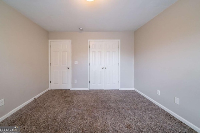 unfurnished bedroom featuring carpet flooring and a closet