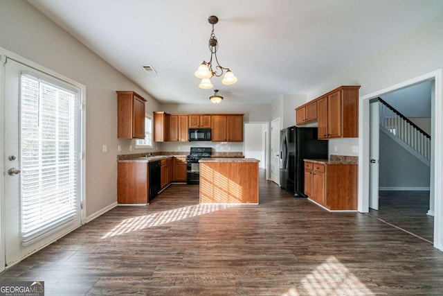 kitchen featuring a center island, an inviting chandelier, dark hardwood / wood-style floors, decorative light fixtures, and black appliances