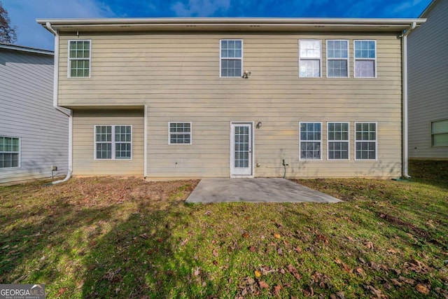 rear view of house with a yard and a patio