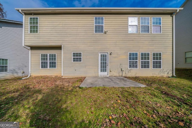 back of property featuring a yard and a patio