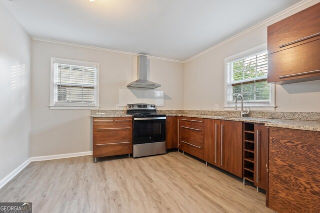 kitchen featuring light stone counters, sink, wall chimney range hood, light hardwood / wood-style flooring, and stainless steel electric range