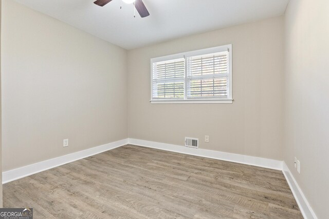 empty room with ceiling fan and light wood-type flooring