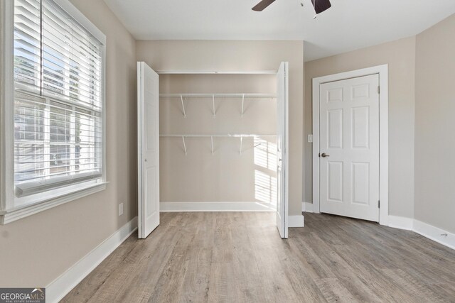 unfurnished bedroom with multiple windows, ceiling fan, and light wood-type flooring