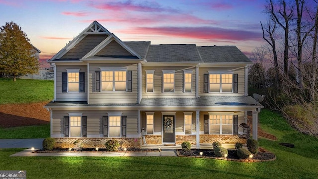 craftsman-style home with a lawn and covered porch