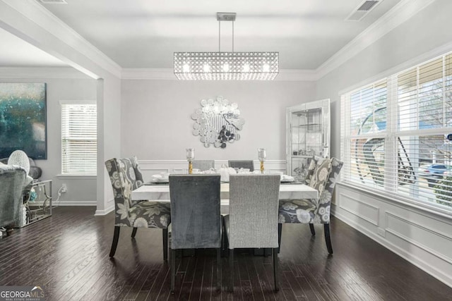 dining room featuring wood-type flooring, a notable chandelier, crown molding, and visible vents