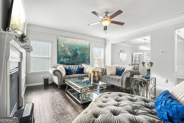 living room featuring a fireplace, visible vents, baseboards, dark wood finished floors, and crown molding