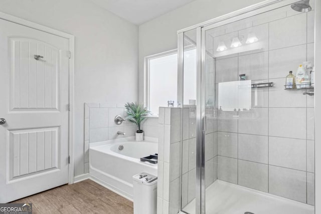 bathroom with hardwood / wood-style floors and independent shower and bath