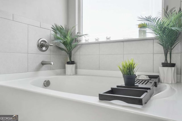 full bath featuring a garden tub and tile walls