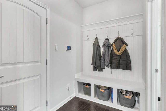 mudroom featuring baseboards and dark wood-type flooring