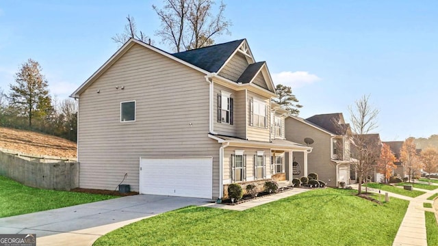 view of side of property with concrete driveway, fence, a yard, and a garage
