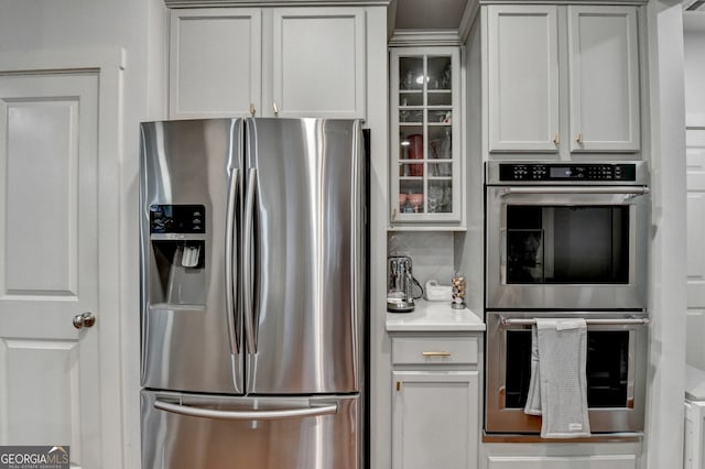 kitchen with white cabinets, backsplash, and stainless steel appliances