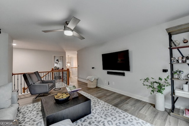 living room featuring light hardwood / wood-style flooring and ceiling fan