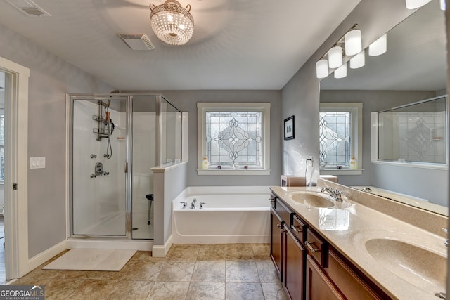 bathroom with a notable chandelier, vanity, and plus walk in shower