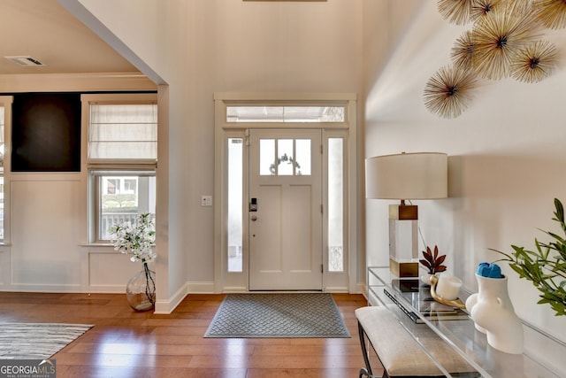 foyer featuring a towering ceiling and dark hardwood / wood-style floors