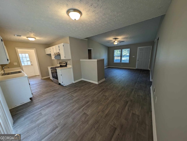 kitchen featuring white cabinets, plenty of natural light, dark wood-type flooring, and stainless steel range