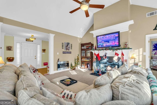 living room with carpet flooring, ceiling fan, high vaulted ceiling, decorative columns, and crown molding