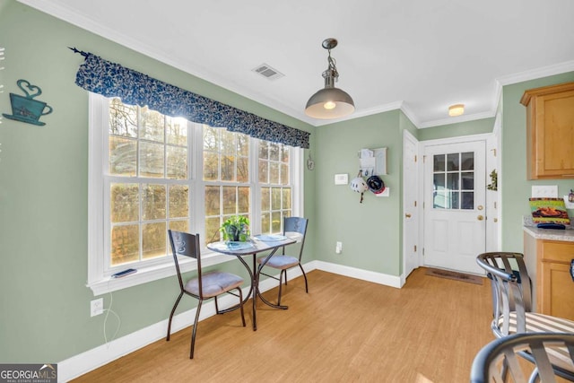 dining area featuring light hardwood / wood-style flooring and crown molding