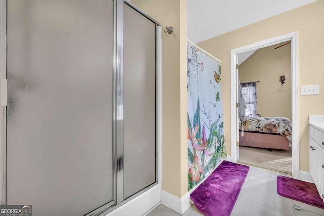 bathroom featuring vanity, walk in shower, and vaulted ceiling