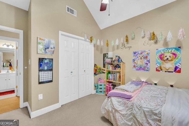 carpeted bedroom with ensuite bathroom, ceiling fan, sink, high vaulted ceiling, and a closet