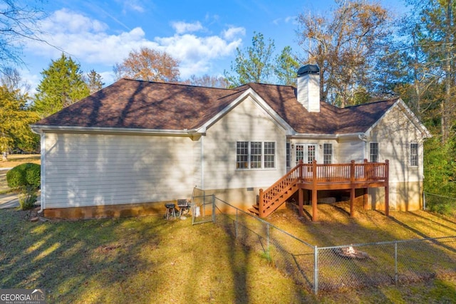 rear view of house with a deck and a yard