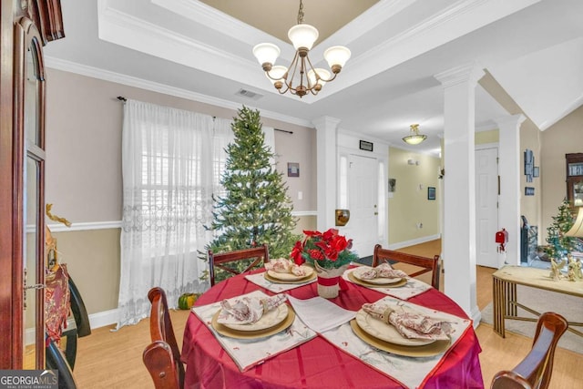 dining space featuring a chandelier, light wood-type flooring, and ornamental molding