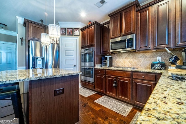 kitchen with light stone countertops, appliances with stainless steel finishes, dark hardwood / wood-style flooring, ornamental molding, and decorative light fixtures