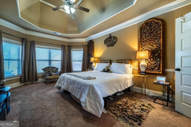 bedroom featuring ceiling fan, carpet floors, ornamental molding, and a tray ceiling